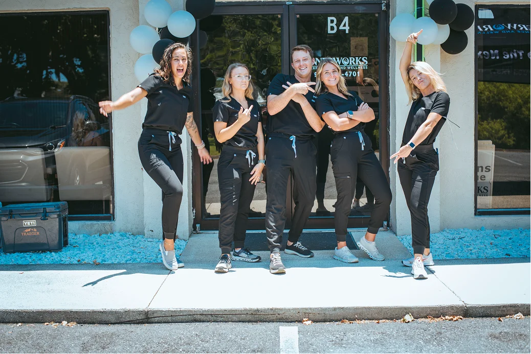 Five healthcare workers pose playfully outside Innerworks clinic